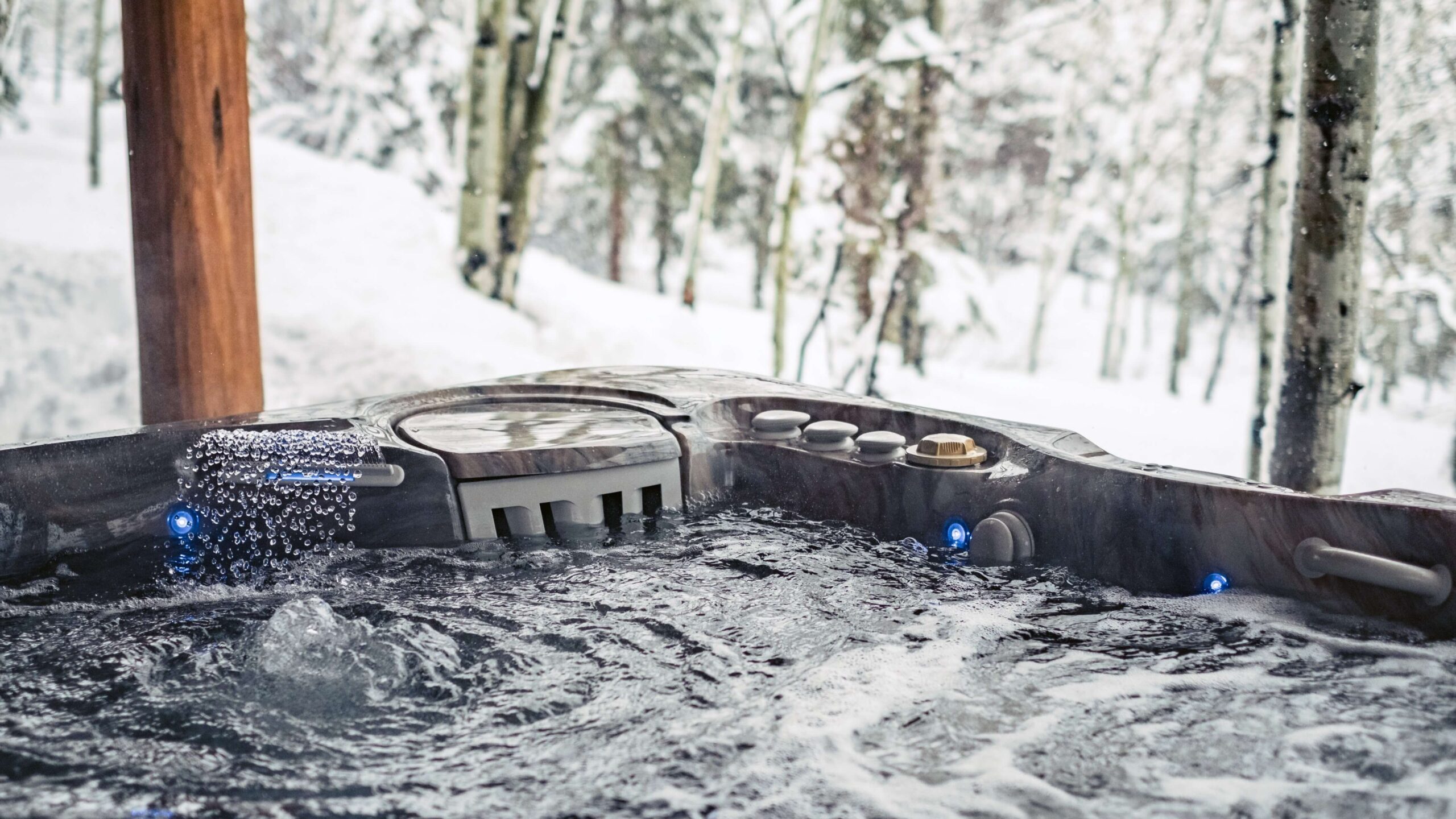 Caldera Spas Utopia Cantabria bubbelbad in de winter. Op de foto is op de achtergrond de winterse sneeuw te zien, terwijl het badwater lekker warm is.